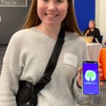 Teenage girl holding a smart phone showing the Smart Steps tree logo